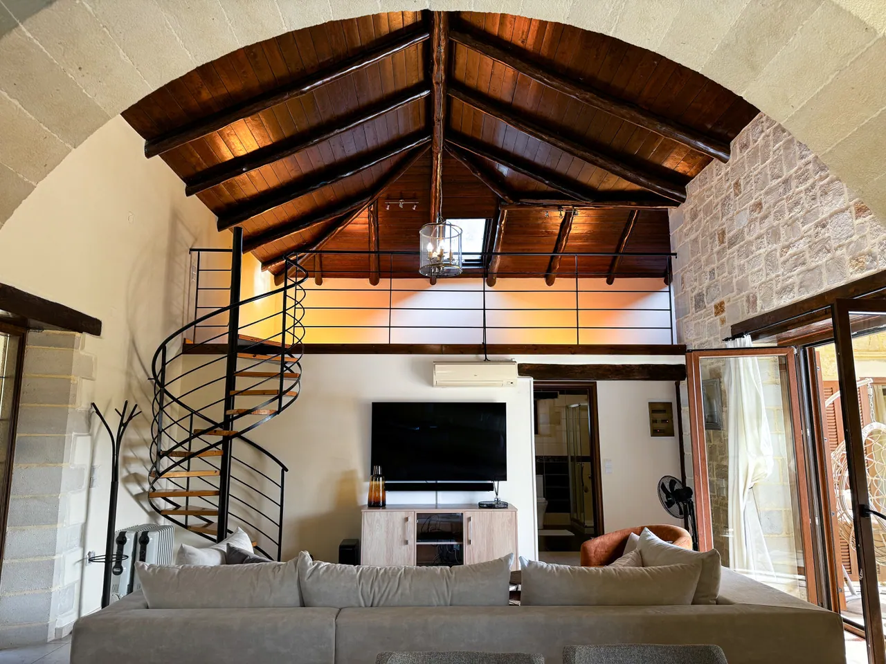 Open-plan living room with mezzanine and wood beam ceiling